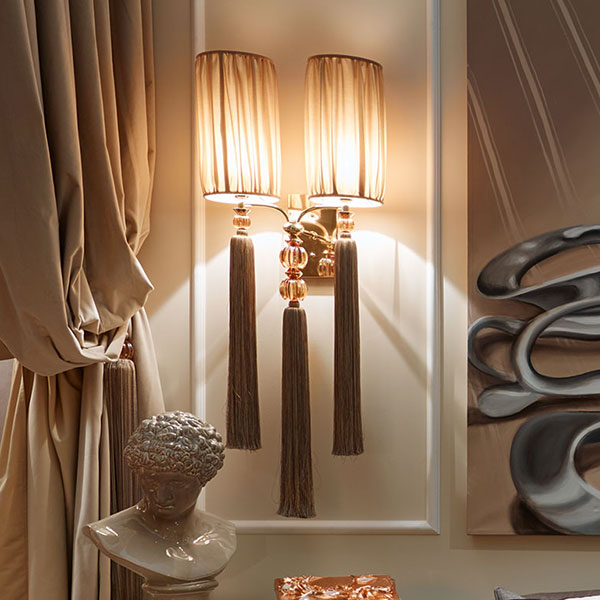 G2193<br>
2-light wall sconce in steel, gold finish with amber crystal ball and tassel, complete with shades
50 x 25 x 115 cm